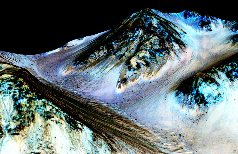 Te wąskie, ciemne, około 100 metrowe smugi prawdopodobnie zostały utworzeone przez przepływającą wodę. Źródło: Credits: NASA / JPL / University of Arizona