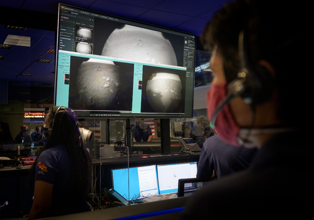 Członkowie zespołu NASA Perseverance obserwują podczas kontroli misji, jak pierwsze obrazy pojawiają się chwilę po tym, jak statek kosmiczny pomyślnie wylądował na Marsie. Źródło: NASA / Bill Ingalls